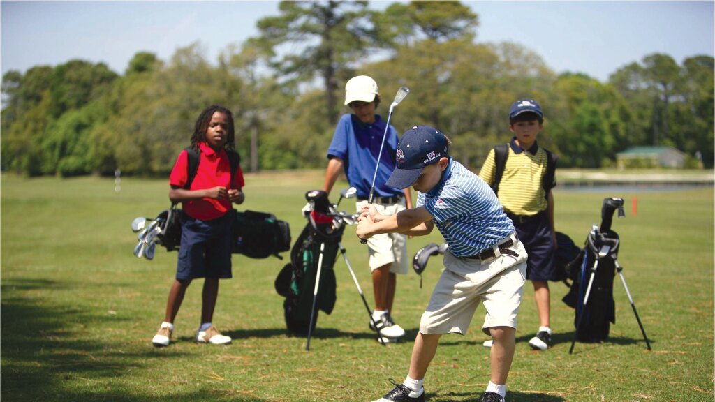 Young golfer taking a swing on golf course